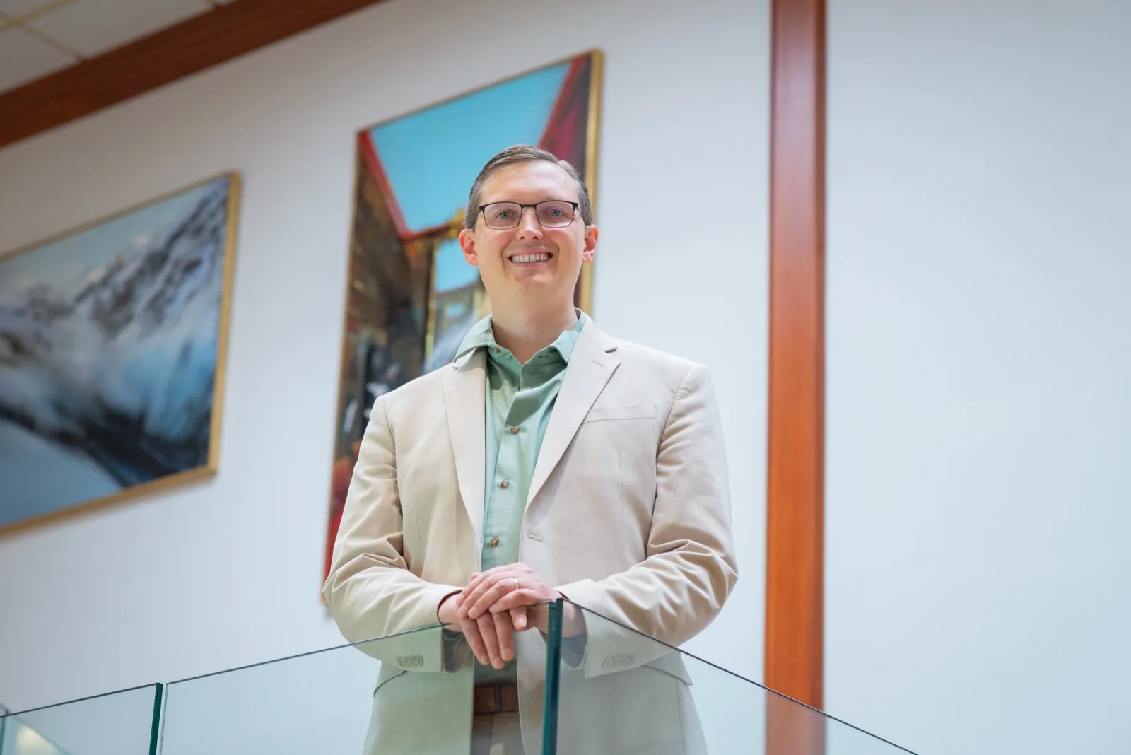 Georg Link leaning on a glass railing, smiling